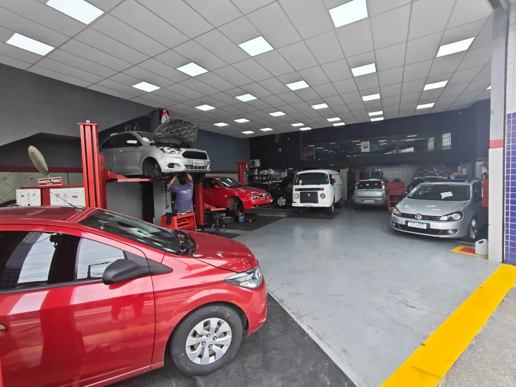 Interior da oficina com elevadores e veículos em manutenção